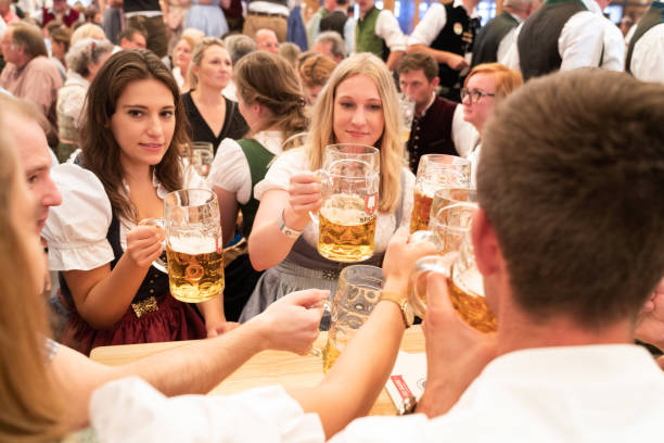 visitatori che celebrano l'oktoberfestfest a beer tent, monaco di baviera, germania - german culture oktoberfest dancing lederhosen foto e immagini stock