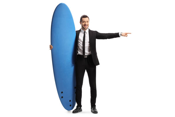 istock Man in a suit holding a surfing board and pointing to the side 1178732504