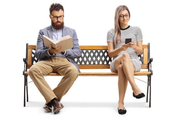 mężczyzna czyta książkę i kobieta siedząca na ławce i literówka przez telefon komórkowy - sitting young men book isolated on white zdjęcia i obrazy z banku zdjęć