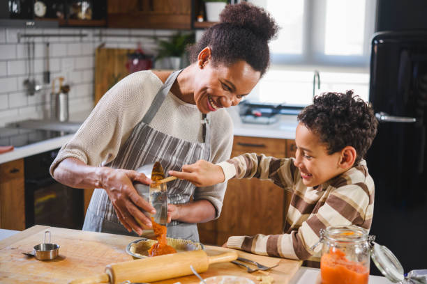 Mother and son baking together Son is helping mother to prepare pumpkin pie. American family. Single mother. Household chores for kids. pumpkin pie stock pictures, royalty-free photos & images