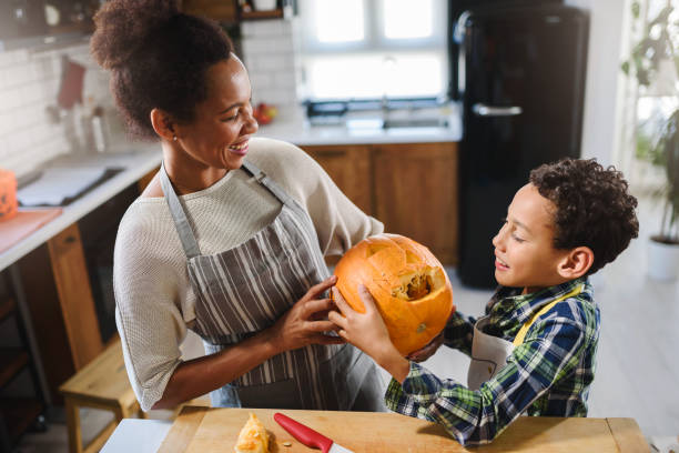 istock Mother and son carving pumpkin making Jack-o-Lantern 1178735370