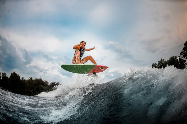 istock Girl wakesurfer jumps with a surf board 1178740097