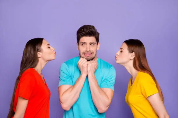 Side profile photo of two beautiful colorful ladies want to kiss one feared, troubled worried handsome grimacing macho isolated violet background