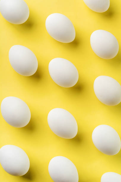 istock White raw chicken eggs lying on light concrete background. Top view. 1178744158