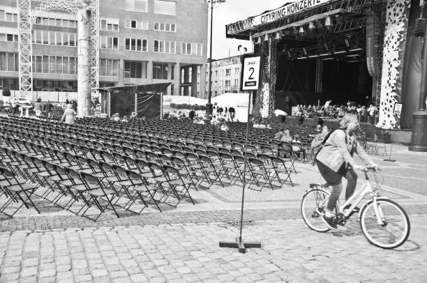 bici da donna oltre una prova d'orchestra a dortmund-stadtgarten friedensplatz (piazza della pace), germania - editorial urban scene horizontal people foto e immagini stock