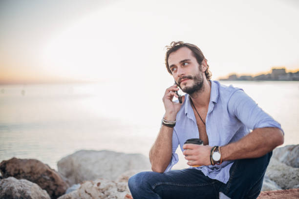 istock Man talking on mobile by the sea 1178747379