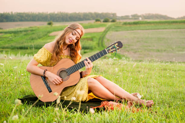 istock young hippie woman with guitar performs a song 1178749798