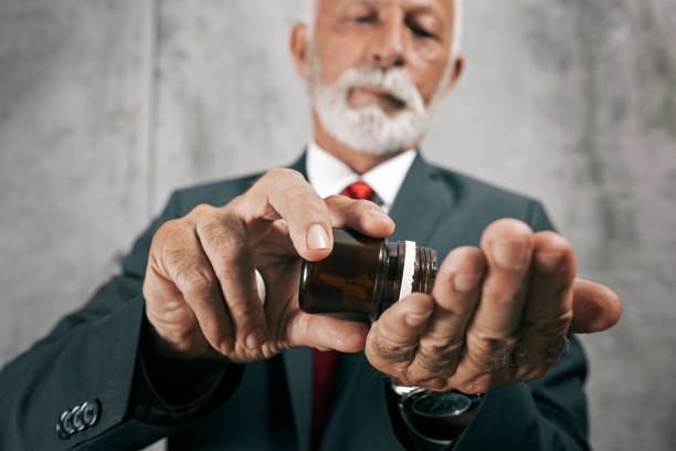 istock Mature Businessman holding pills 1178750696