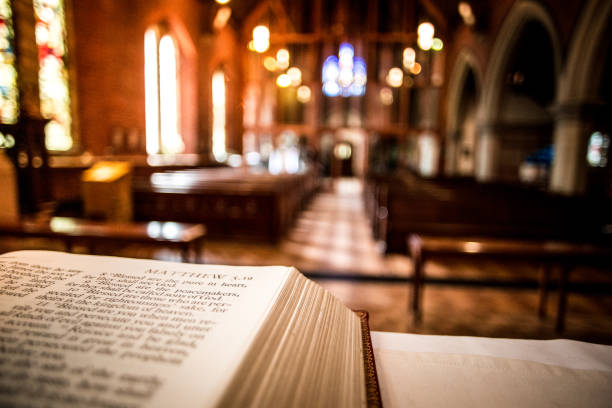 照らされた教会の中の祭壇に聖書を開く - anglican ストックフォトと画像