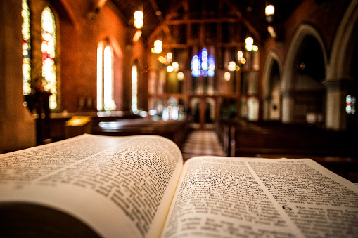 Abra la Santa Biblia en el Altar dentro de la iglesia iluminada photo