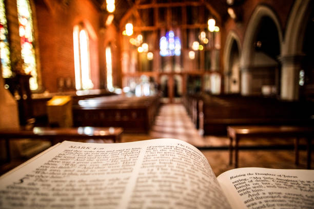 istock Open Holy Bible on Altar inside illuminated church 1178750851