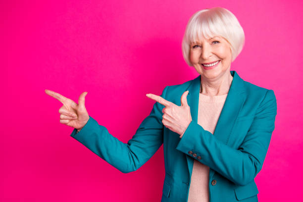 istock Portrait of her she nice-looking attractive lovely representative elegant classy cheerful glad gray-haired lady pointing aside ad isolated over bright vivid shine vibrant pink fuchsia color background 1178753362