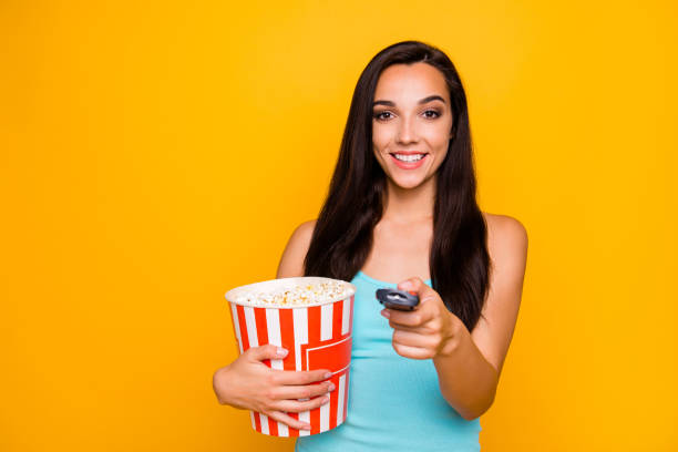 istock Photo of cheerful attractive charming cute nice tv watcher holding controller with her hands pop corn pot watching comedy wearing teal tank-top isolated over vivid color background 1178754867