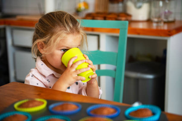 istock Little girl drinking water from green cup 1178755896