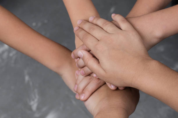 istock children hand together in a circle with palms down on gray background 1178761157