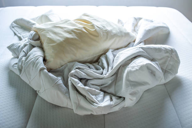 istock White crumpled bed sheet, Ivory pillow on white bed, Close up shot, Selective focus, Bedroom cleaning concept 1178761373