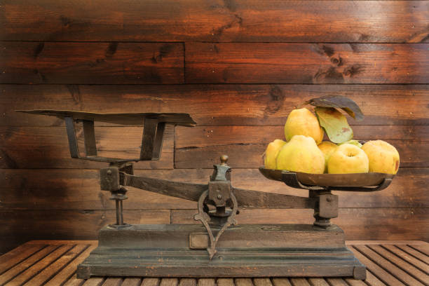 Harvesting fruit from the orchard of the linens placed in a vintage brass and copper scale in a rustic still life with wooden background harvest of fruits from the orchard in the fall - rustic photo on a wooden background - quinces with vintage weighing scale vintage kitchen scale with fruit stock pictures, royalty-free photos & images