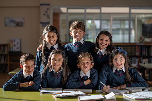 Portrait of a happy group of Latin American students smiling in the classroom and looking at the camera â education concepts