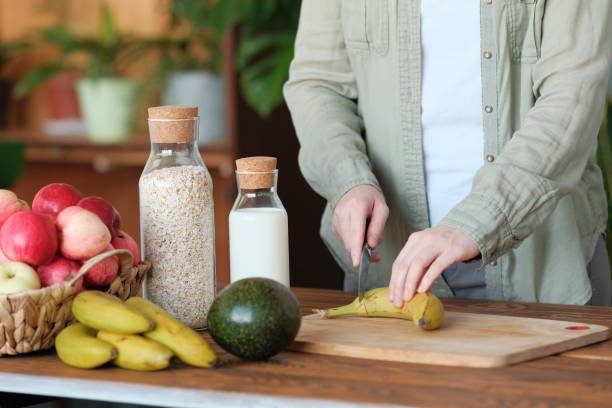istock Girl cuts a banana for smoothie. 1178763410