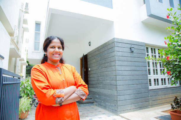 Woman standing outside home stock photo Moving House, Outdoors, House, south, south indian lady stock pictures, royalty-free photos & images