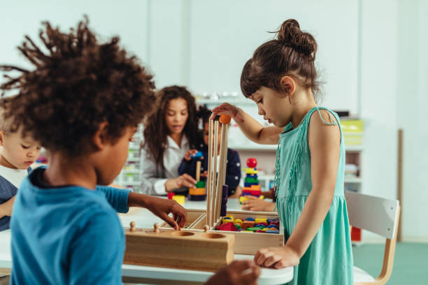 We play, learn and grow together Adorable little children and their teacher playing with toys at kindergarten preschool student stock pictures, royalty-free photos & images