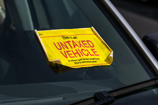 UK Untaxed Vehicle sticker on the windscreen of a parked car