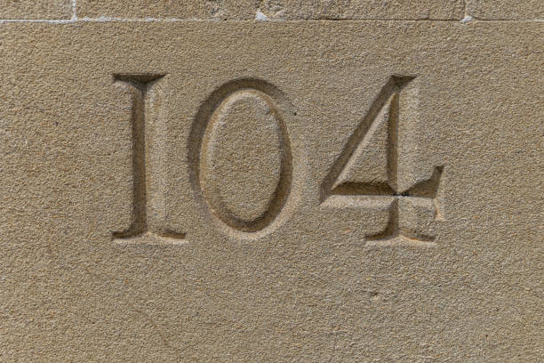 istock Number 104 carved in a limestone ashlar wall 1178767571