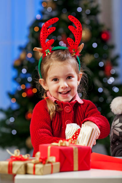 istock Smiling girl opening presents 1178769716