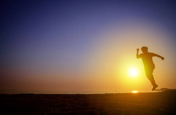 istock Silhouette of Man running on the beach at sunset 1178769785