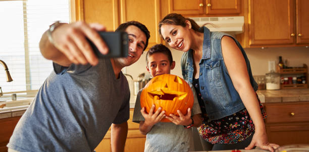 istock family taking selfie with jack-o-lantern for halloween 1178771829