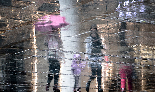 Reflections of buildings in a pavement on a rainy day