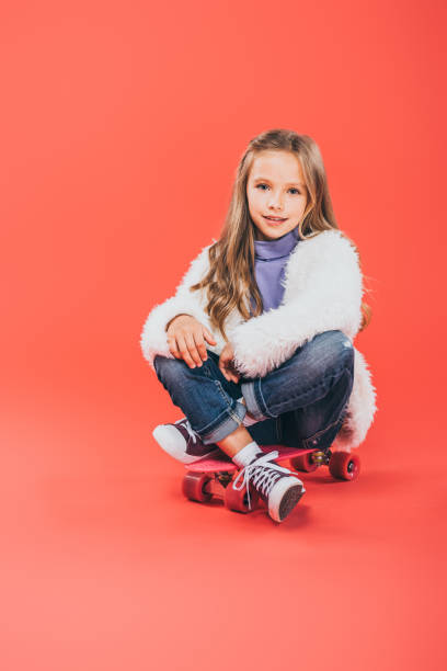 istock smiling kid in autumn outfit sitting on skateboard on red 1178775237