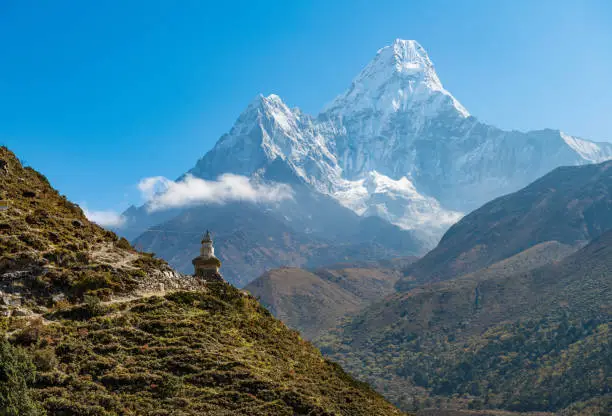 Photo of The Buddhist stupa at the edge of the mountain with beautiful with of Mt.Ama Dablam one of the most beautiful mountain in the World.
