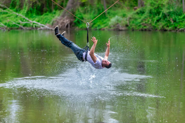 istock young man flying down on zipline over the river, extreme sport 1178778468