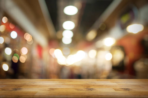 istock Empty wooden table in front with blurred background of night market. 1178778917