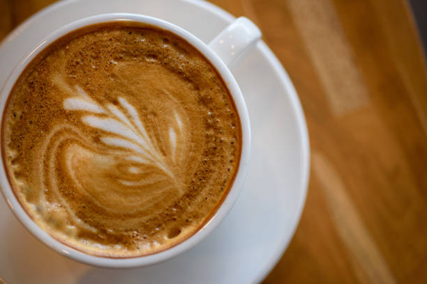 istock Coffee with latte art in white cup on wooden table 1178778936