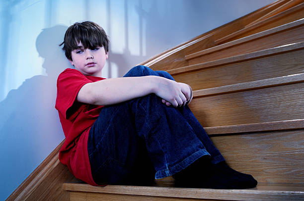 istock Depressed child sitting on staircase 117878201