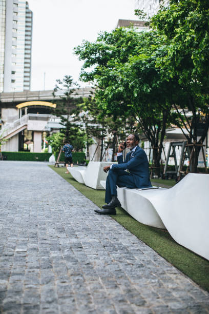 istock Businessman Sitting Outdoors and Talking on his Cell Phone 1178788060