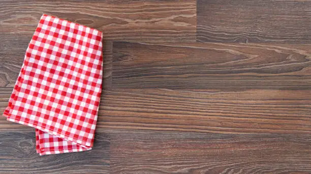 Kitchen plaid textile on old rustic wood. Food menu background
Red checkered tablecloth