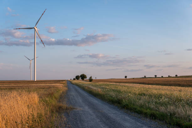 istock Dirt Road next to wind turbine 1178792434