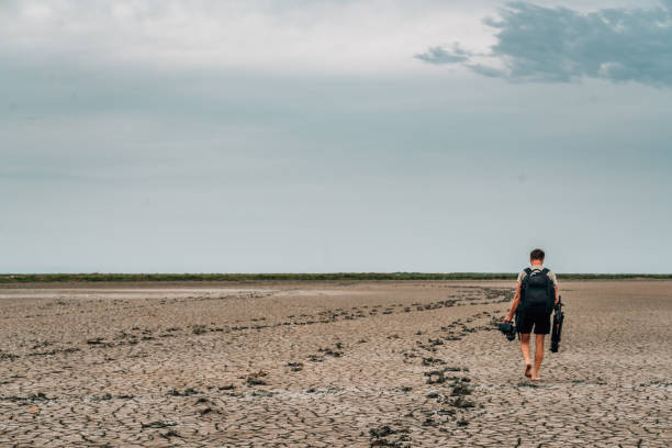 Photographer walking through dried mud, Provence