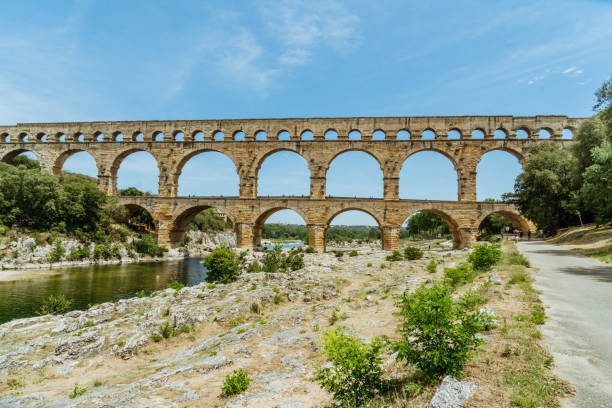rio que flui o aqueduto antigo, vers-pont-du-gard, gard, france - aqueduct roman ancient rome pont du gard - fotografias e filmes do acervo