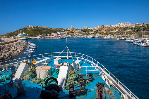 Malta - August 15th 2019: A view from the Gozo Channel Line passenger and vehicle ferry approaching the island of Gozo.