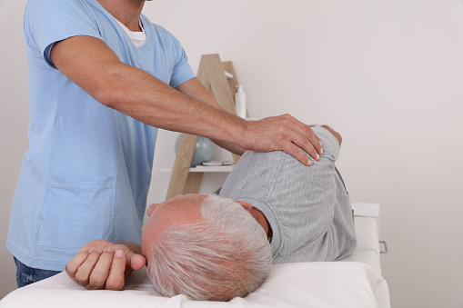 Chiropractic / Osteopathy treatment, Back pain relief. Physiotherapy for senior male patient, sport injury recovery , Kinesiology