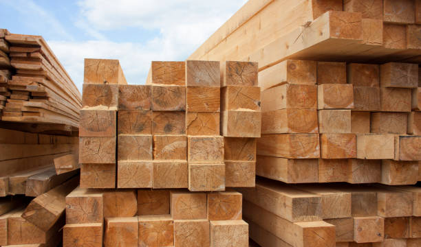 magazijn van lumber. houten planken en hout gestapeld in stapels buitenshuis - dakbalk stockfoto's en -beelden