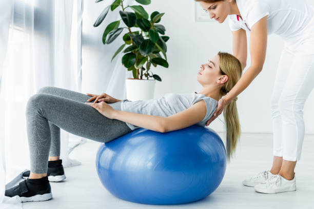 istock attractive patient lying on blue exercise ball and chiropractor touching her shoulders 1178798969