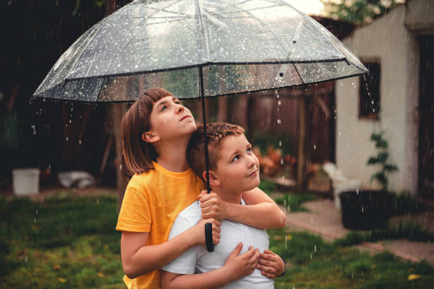 istock Brother and sister enjoying rain 1178800230