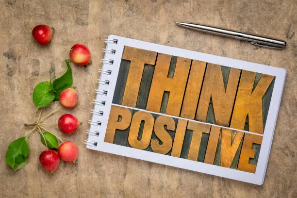Think positive - word abstract in vintage letterpress wood type in an art sketchbook, flat lay with crab apples, optimism, thinking and mindset concept