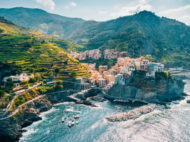 Aerial view of town in mountains towering over tranquil sea,  Cinque Terre, Italy