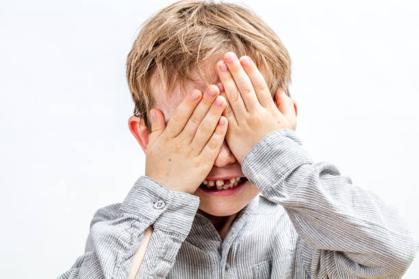 istock joyful smiling child hiding his face playing hide and seek 1178804054